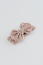 Avauma Mellow Ribbon Band in Baby Blush – Flat lay of soft pink corduroy bow headband